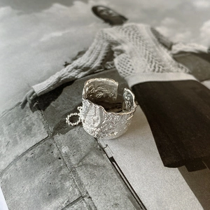 Detailed macro view of 925 silver wide open ring with irregular lava foil texture and chain