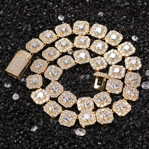 Close-up of golden hip hop chain with clear zircons on black stone background