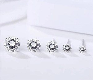 Macro view showing five different sizes of round cubic zirconia studs in silver settings