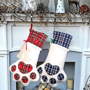 Christmas dog paw stockings with red and blue plaid patterns hanging on fireplace mantle