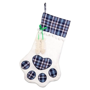 Close-up of paw-shaped Christmas stocking with blue plaid fabric and bone tags