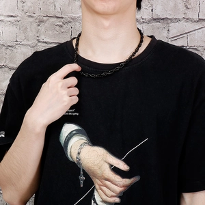 Men's black twist rope chain necklace made of titanium steel on model with brick background