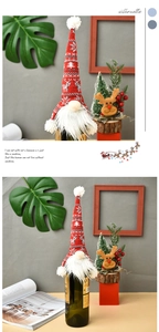 Detail of red knitted gnome wine bottle cover with snowflake patterns for Christmas decor