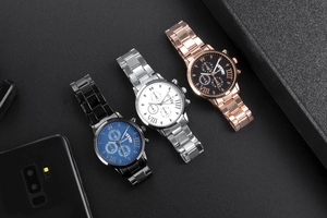 Detailed close-up of three quartz watches with metal straps and Roman numeral dials
