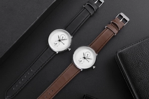 Gros plan de deux montres à quartz pour hommes avec bracelets en cuir dans un coffret