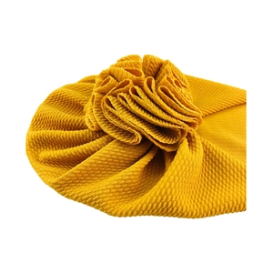 Detailed view of the yellow fabric flower and waffle texture on the baby turban hat