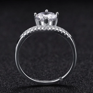 Detail view of silver ring showing four-prong setting and pavé crystals on the band