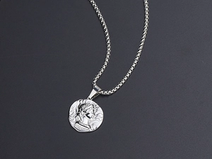 Detail of silver embossed coin pendant necklace with classical portrait and box chain
