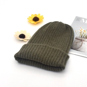 Detailed view of army green ribbed knit beanie with sunflower decor on white background