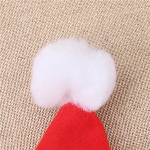 Detailed view of red Christmas hat with soft white pompom and festive felt texture
