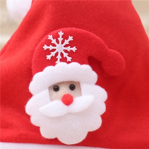 Detailed close-up of felt Christmas hat featuring a Santa Claus applique and snowflake motif
