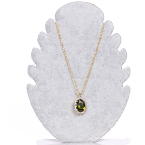 Detail of a gold necklace with oval green gemstone pendant on grey velvet display stand
