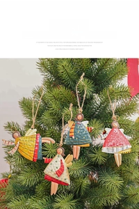 Close-up of four painted alloy angel ornaments hanging on Christmas tree branches