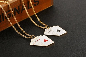 Macro shot of gold poker card pendants with sparkling cubic zirconia on twisted chain