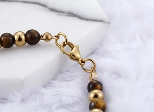 Detail of the golden tiger eye bead bracelet featuring a secure lobster clasp and metal beads