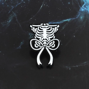 Gothic punk style skeleton ribcage brooch with a bow on dark starry background
