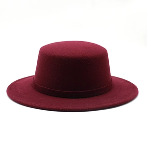 Detailed macro view of burgundy felt boater hat featuring a flat brim and matching hat band