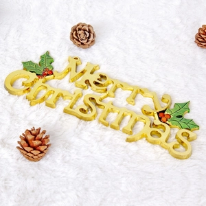 Golden Merry Christmas hanging ornament with holly leaves on white plush background