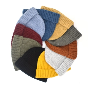 Flat lay of colorful ribbed knit beanies in various shades on a white background