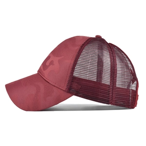 Detailed side view of camouflage ponytail baseball cap with breathable mesh and dark red brim