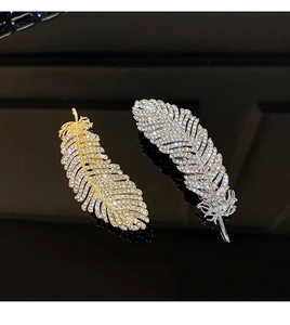 Detailed macro view of gold and silver feather hair clips with sparkling crystal rhinestones