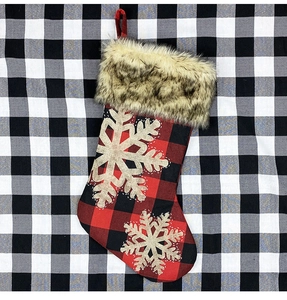 Détail de chaussette de Noël à carreaux avec bordure en fourrure et flocon