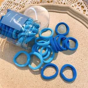 Thickened blue elastic hair bands set in a clear plastic jar with a towel texture