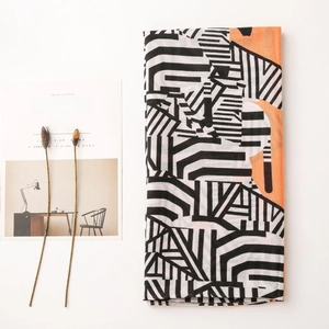 Detail shot of lightweight cotton linen scarf with black white geometric stripes and orange block