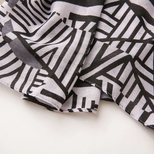 Macro shot of lightweight scarf featuring black and white geometric patterns and fine texture
