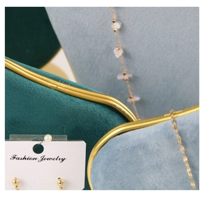 Detailed macro view of velvet jewelry display stand with golden metal edges and fine texture