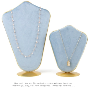 Light blue velvet jewelry stands with gold metal base showing necklace and peanut pendant