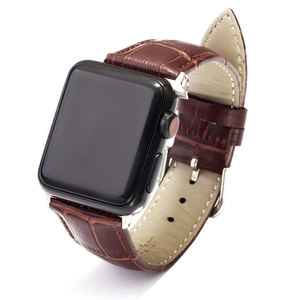 Detailed macro view of brown crocodile texture leather watch strap with silver buckle