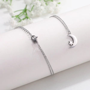 Elegant silver star and moon pendant necklace made of stainless steel on white pedestal