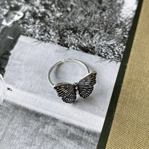 Macro shot of retro butterfly silver ring on a fashion magazine with vintage finish