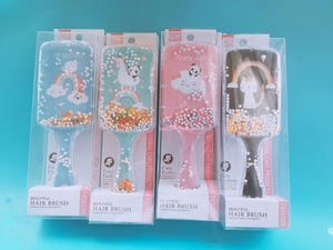 Detailed set of four colorful cartoon glitter hairbrushes in clear packaging