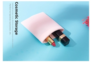 Pink plush microfiber pouch used as a makeup bag with lipsticks on blue background