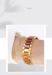 Detail of rose gold watch band with brown enamel accents and matching thin chain bracelet