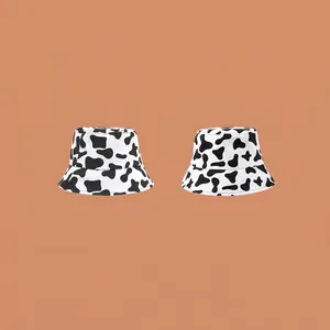 Unisex cow print bucket hat in black and white cotton for stylish sun protection