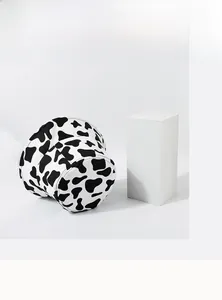 Detail of black and white cow print bucket hat in durable canvas fabric with wide brim