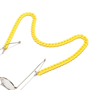 Dettaglio di una catena per occhiali in acrilico giallo acceso dallo stile chunky