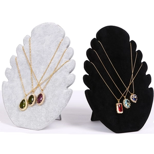 Close-up of gray and black velvet jewelry stands displaying various colorful gemstone necklaces