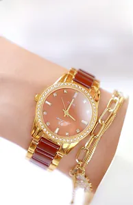 Detail of rose gold crystal watch featuring brown ceramic links on a woman's wrist