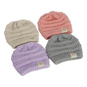 Detail of four knit beanies in cream pink purple and grey with soft fleece lining