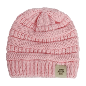 Detailed knit texture of a pink children knit beanie with a MOK KIDS patch on white background