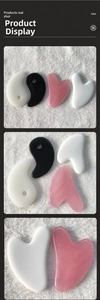 Macro detail of heart-shaped and tai chi resin gua sha tools in white, pink, and black