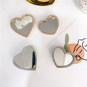 Detailed view of heart-shaped phone grips with rhinestones and mirrors in gold and silver