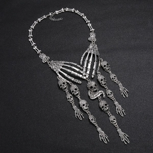 Makroaufnahme einer silbernen Gothic-Halskette mit Totenköpfen und Skeletthänden