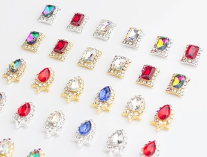 Macro shot of K9 glass nail rhinestones in droplet and octagon shapes with metallic bases