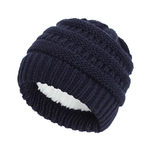 Detail of dark blue cable knit baby hat with soft white fleece lining for winter warmth
