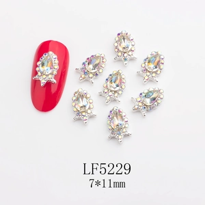 Macro detail of teardrop glass nail rhinestones with silver crown base and AB accent stones